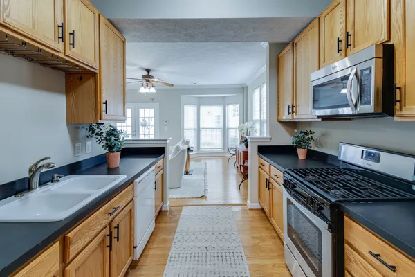 a kitchen with stainless steel appliances granite countertop a sink stove and cabinets