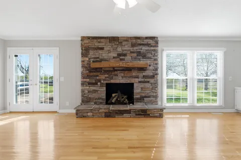 a living room with a fireplace and a floor to ceiling window