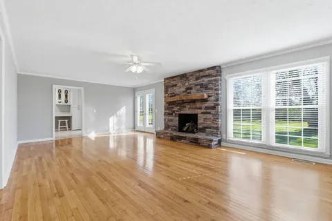 a view of empty room with wooden floor and fireplace