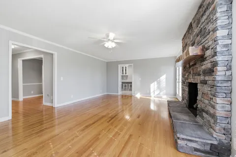 a view of empty room with wooden floor and fireplace