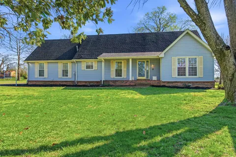 a front view of a house with a yard and potted plants