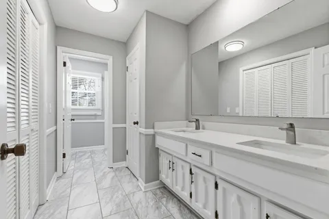 a bathroom with a double vanity sink and a mirror