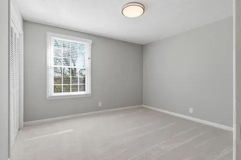 an empty room with windows and closet