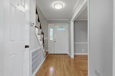 a view of a hallway with wooden floor and staircase