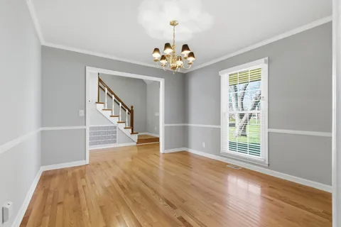 a view of an room with wooden floor chandelier and windows