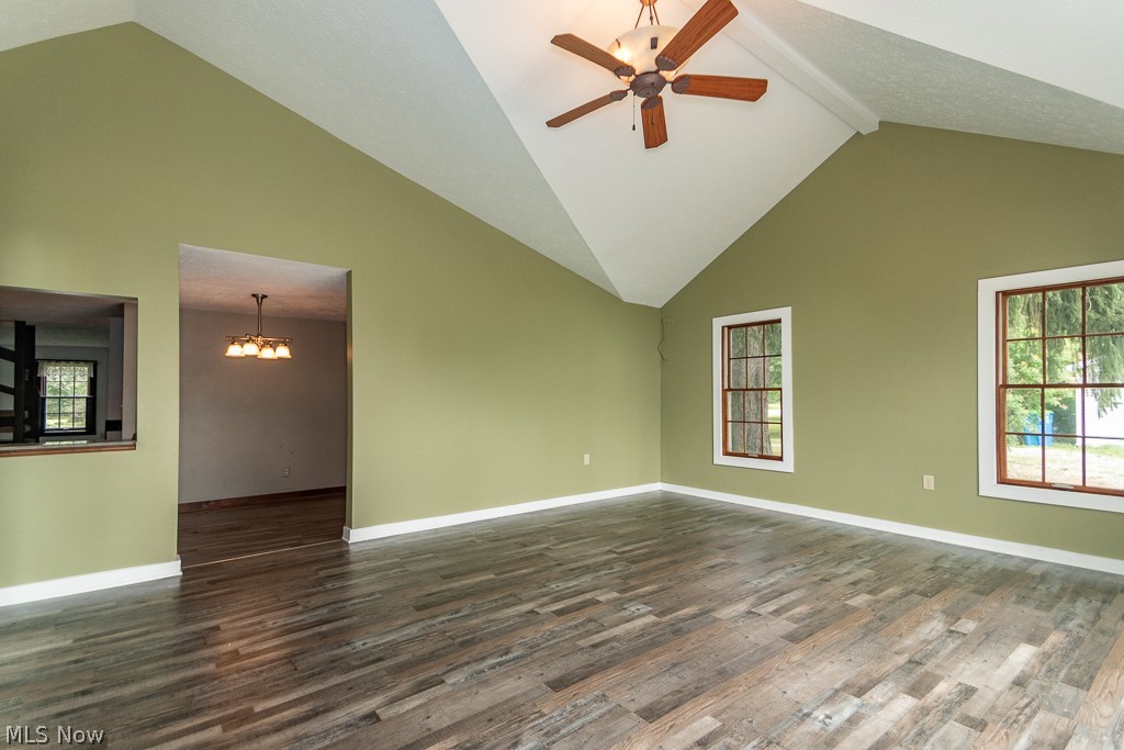 11601 Bass Lake Road Chardon, OH 44024 - Photo 15 of 50 Spare room featuring beam ceiling, dark wood-type flooring, ceiling fan with notable chandelier, and high vaulted ceiling