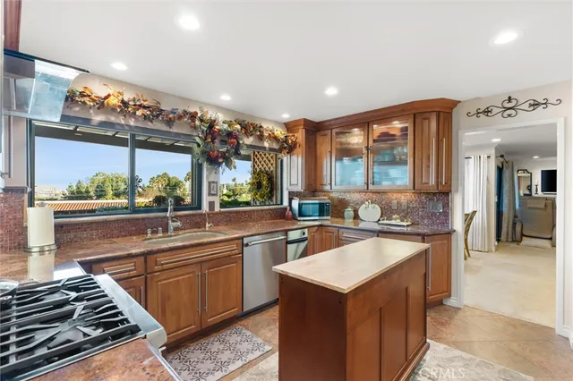 a kitchen with kitchen island granite countertop a stove and a sink