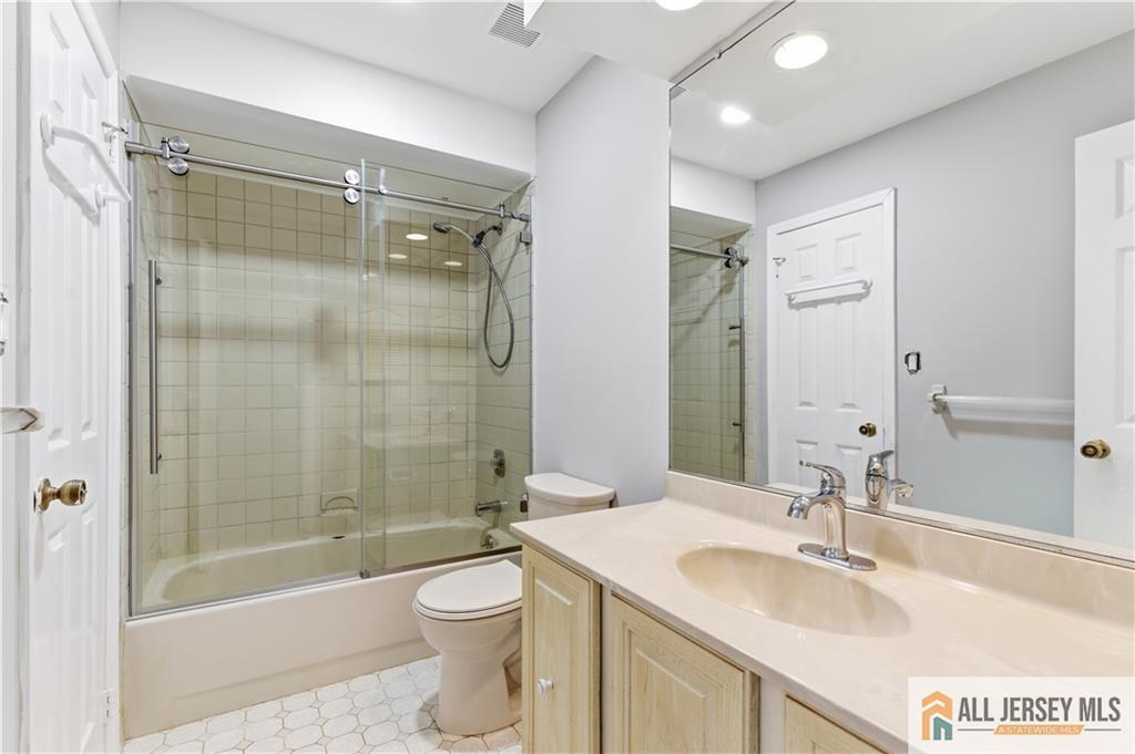 809 Woodbridge Commons Way, Unit 809 Iselin, NJ 08830 - Photo 14 of 16 a bathroom with a sink mirror toilet and bathtub