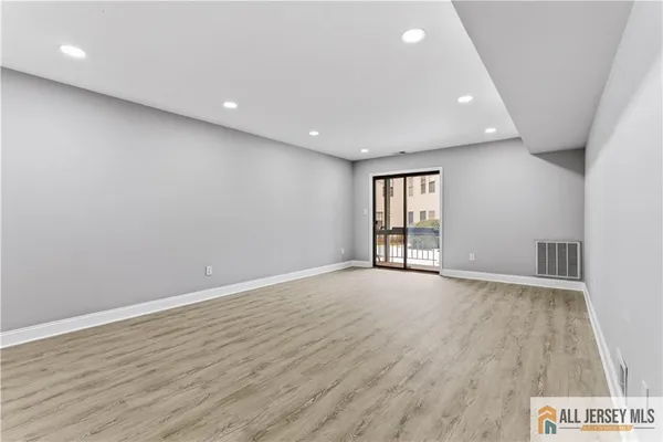 an empty room with wooden floor and sliding door