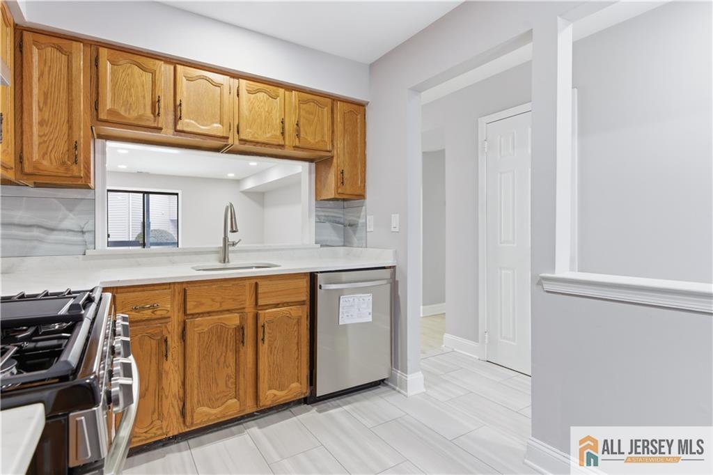 809 Woodbridge Commons Way, Unit 809 Iselin, NJ 08830 - Photo 8 of 16 a kitchen with stainless steel appliances granite countertop a stove and a sink