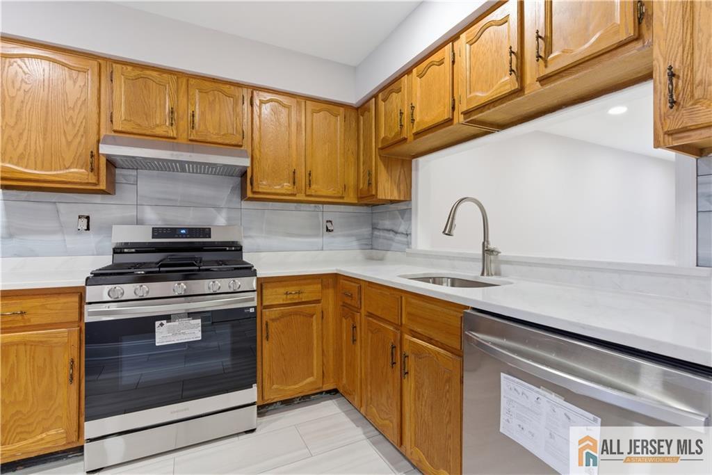809 Woodbridge Commons Way, Unit 809 Iselin, NJ 08830 - Photo 9 of 16 a kitchen with stainless steel appliances granite countertop a sink and a stove