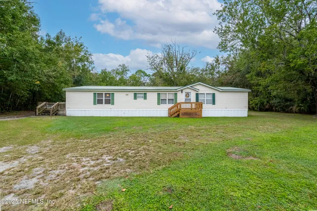 a view of a house with a yard and sitting area