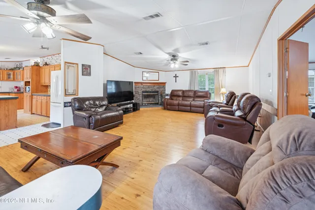 a living room with furniture a flat screen tv and kitchen view