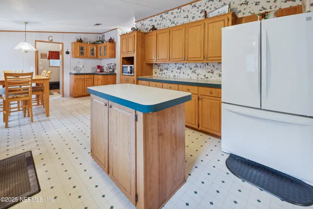 a kitchen with stainless steel appliances a stove a refrigerator and a wooden cabinets