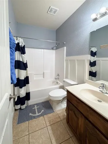 a view of an empty room and chandelier fan