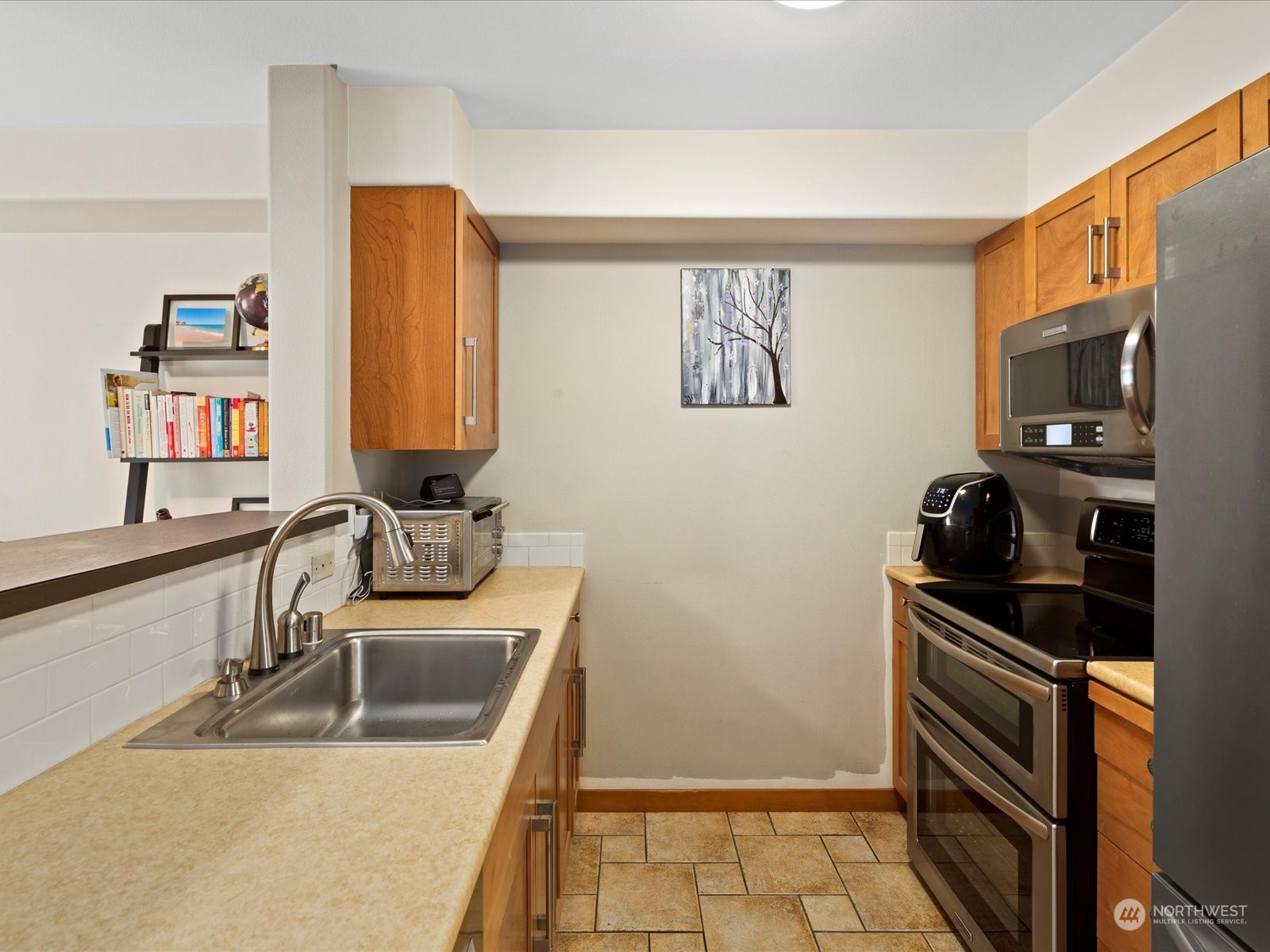 3015 Southwest Avalon Way, Unit 407 Seattle, WA 98126 - Photo 14 of 27 a kitchen with stainless steel appliances granite countertop a sink and a refrigerator