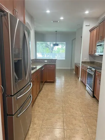 a kitchen with stainless steel appliances granite countertop a refrigerator and a sink