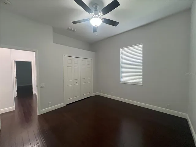 an empty room with a window and a fan