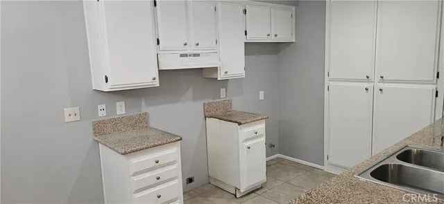 a kitchen with granite countertop white cabinets and stainless steel appliances