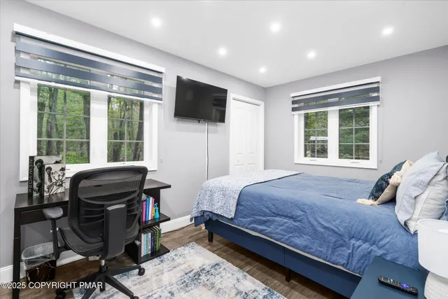 a bedroom with a bed and wooden floor