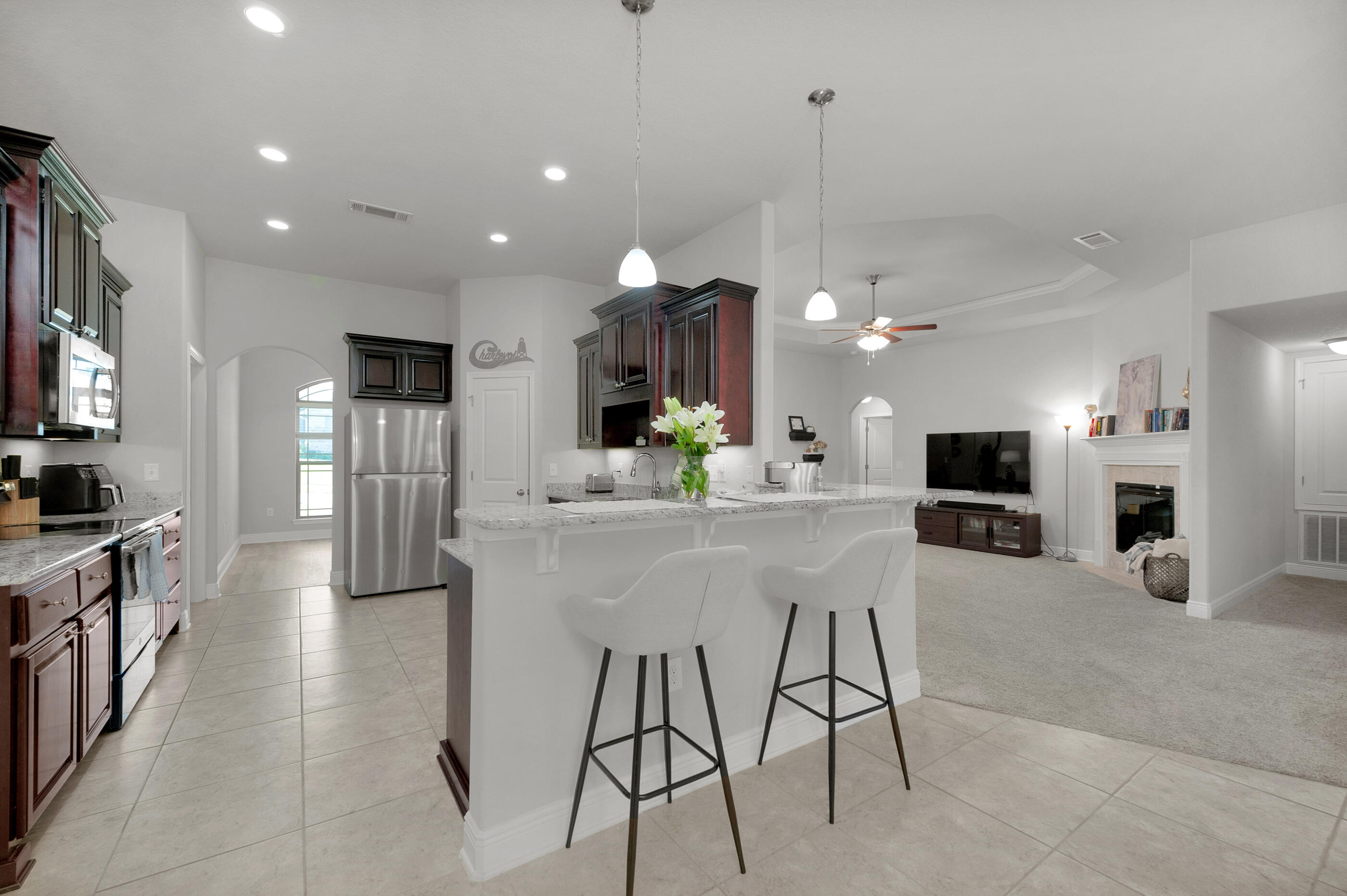 306 Vale Loop Crestview, FL 32536 - Photo 11 of 40 a kitchen with stainless steel appliances kitchen island granite countertop a refrigerator oven a sink dishwasher and a dining table with chairs
