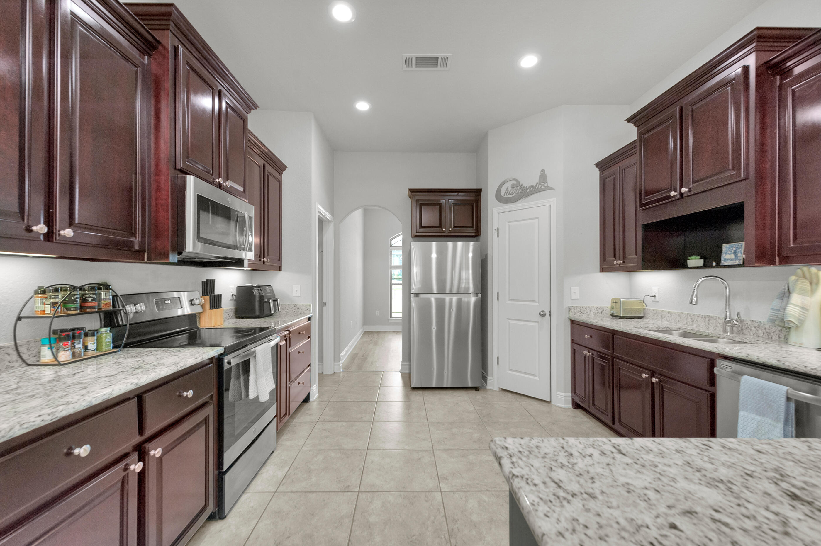 306 Vale Loop Crestview, FL 32536 - Photo 13 of 40 a kitchen with stainless steel appliances granite countertop a sink stove and refrigerator