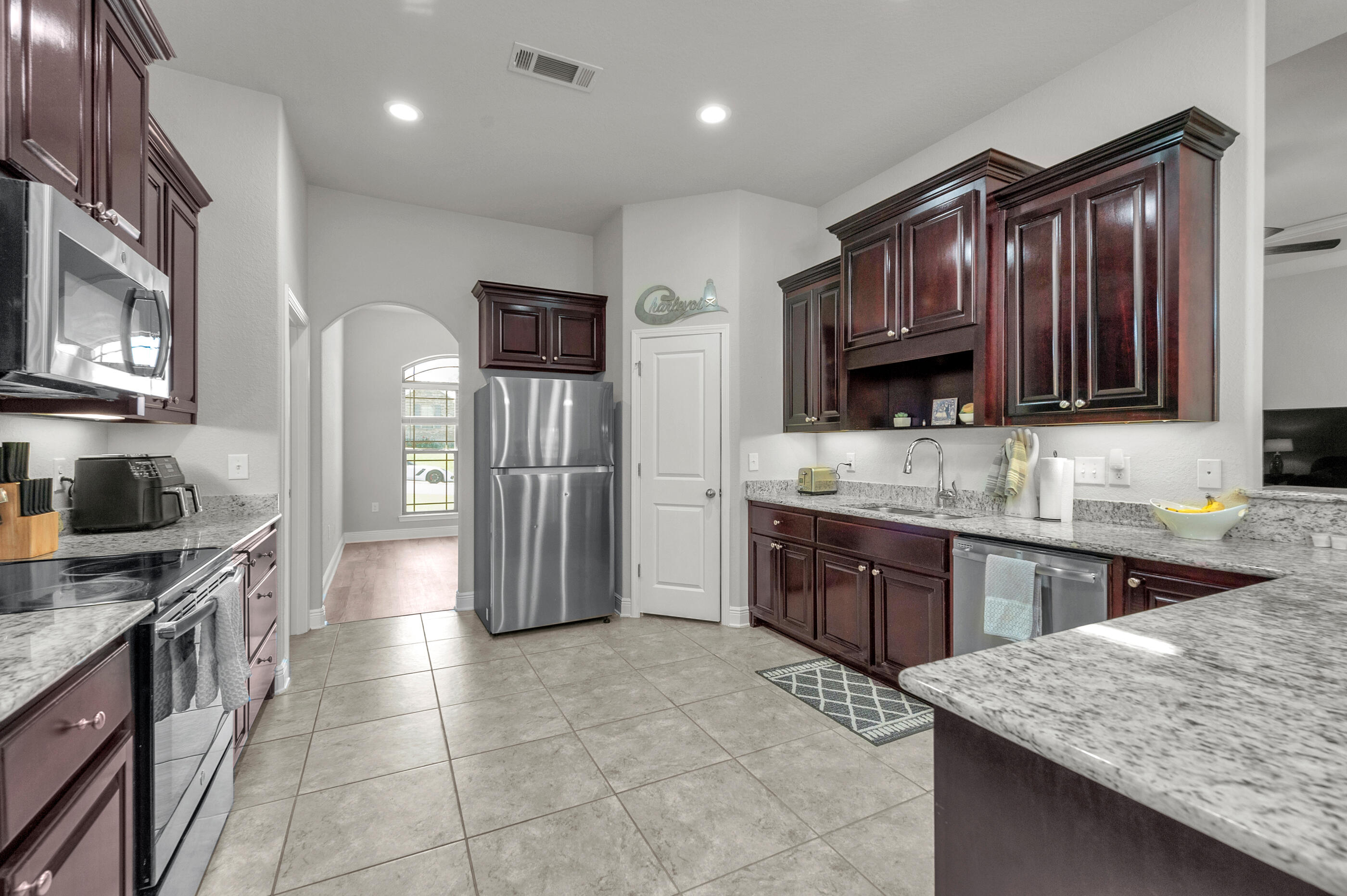 306 Vale Loop Crestview, FL 32536 - Photo 14 of 40 a large kitchen with stainless steel appliances granite countertop a stove refrigerator and cabinets