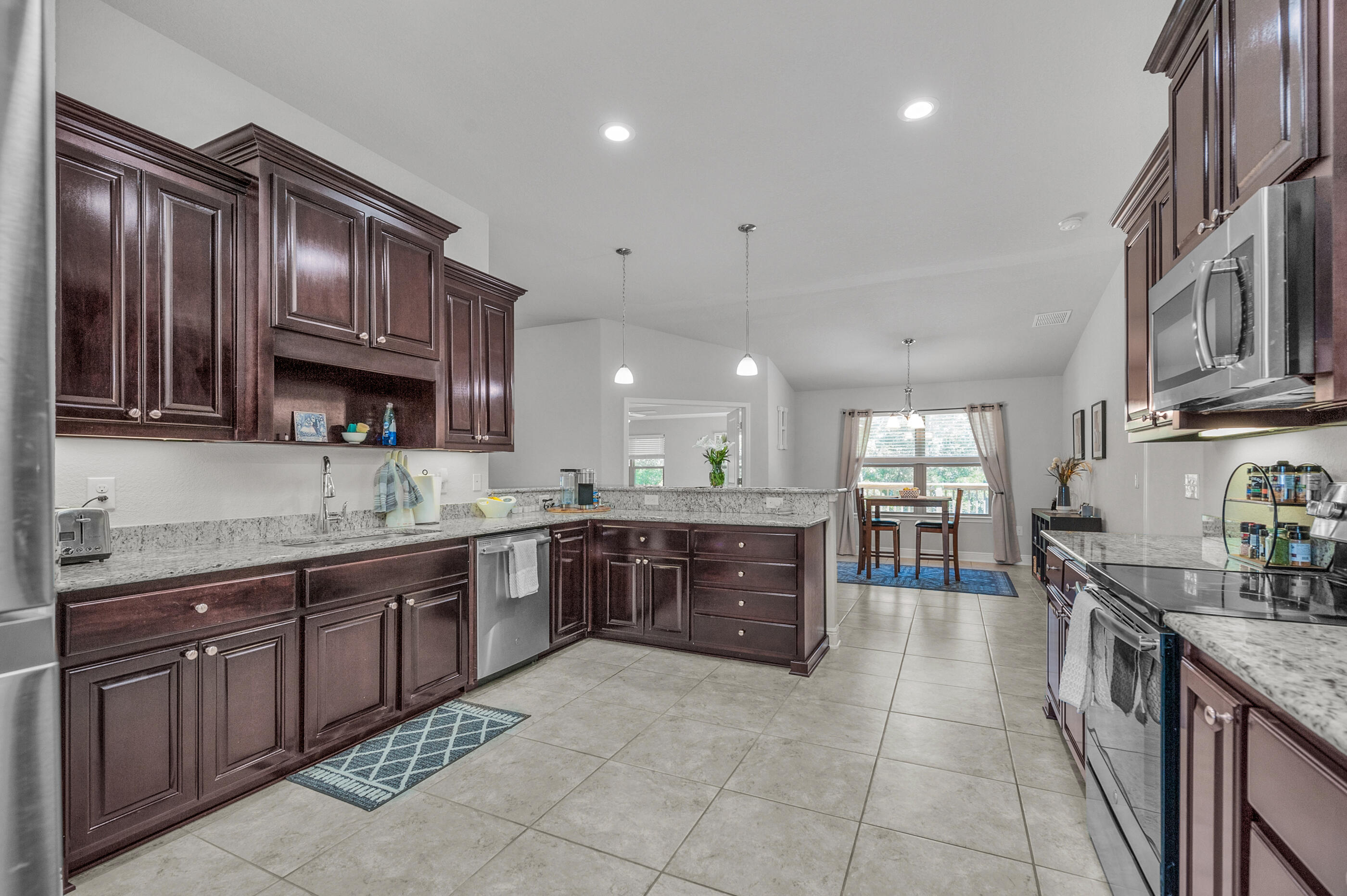 306 Vale Loop Crestview, FL 32536 - Photo 15 of 40 a large kitchen with stainless steel appliances wooden cabinets a stove and a sink