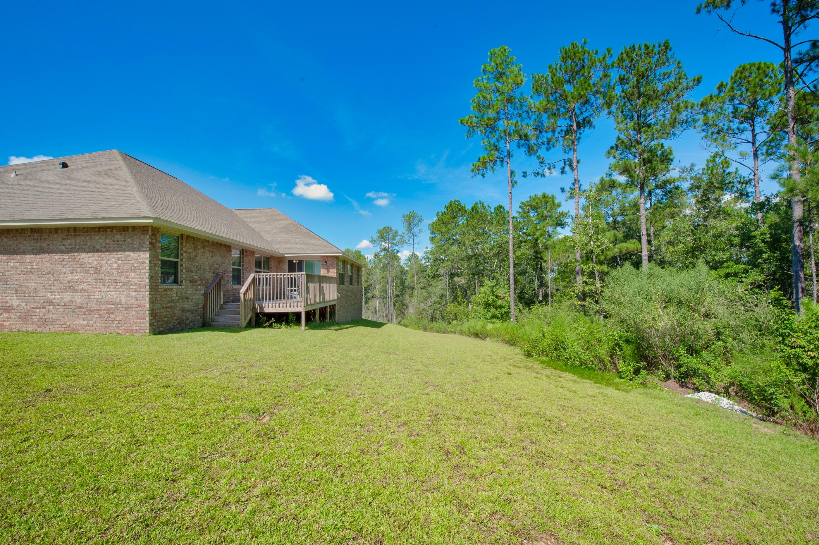 306 Vale Loop Crestview, FL 32536 - Photo 39 of 40 a yellow house with trees in front of it