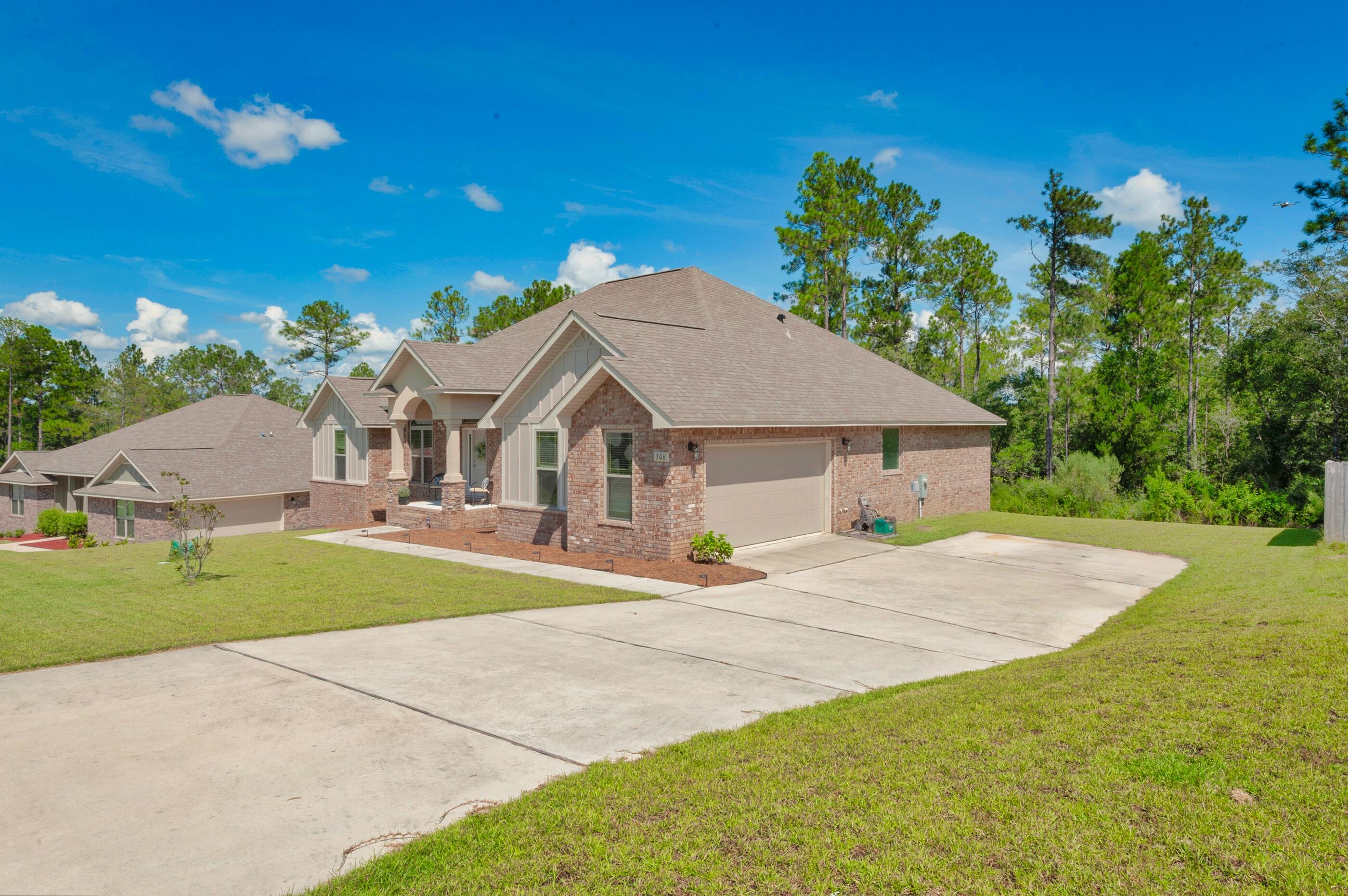 306 Vale Loop Crestview, FL 32536 - Photo 4 of 40 a front view of a house with a yard and garage