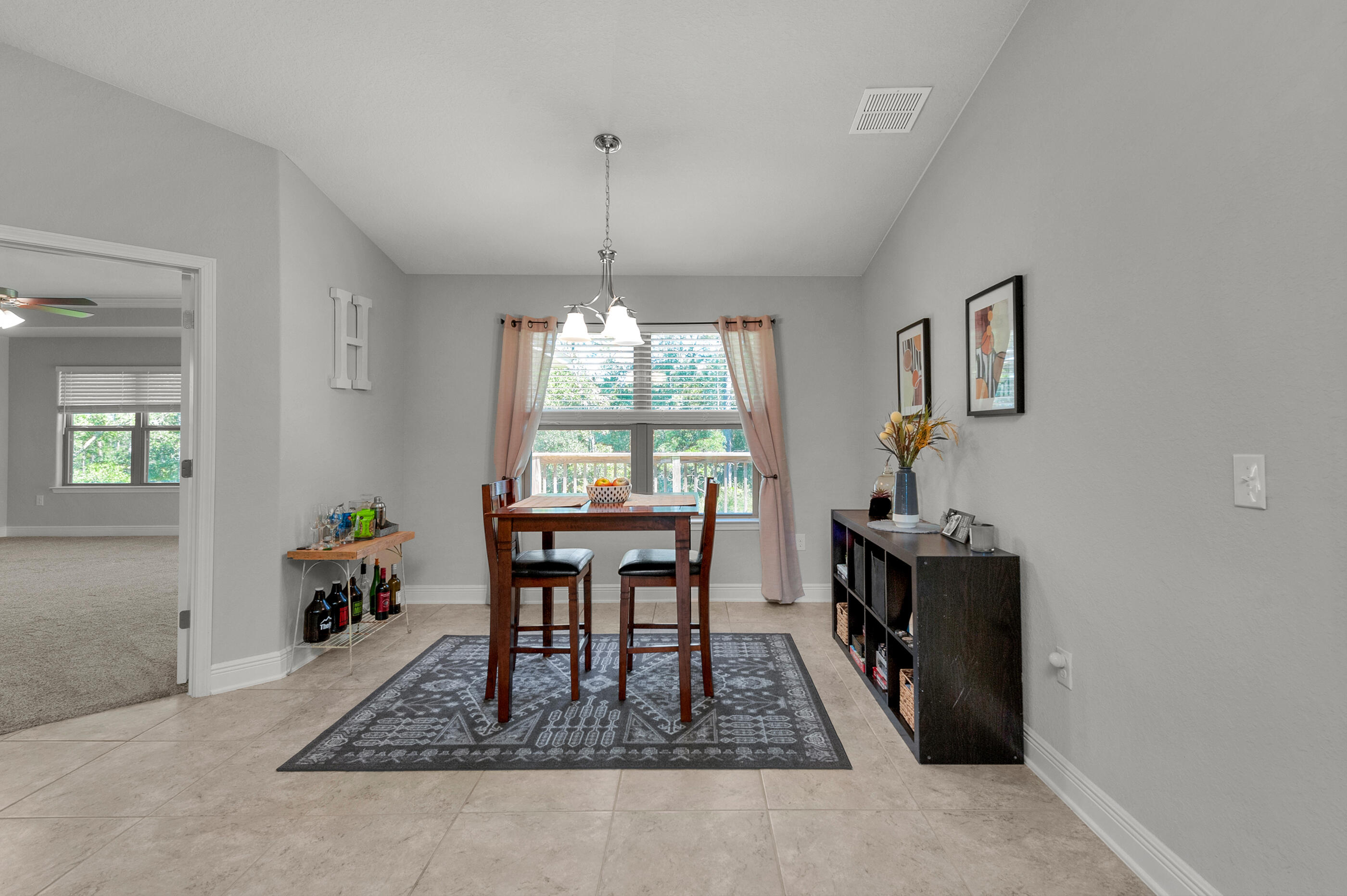 306 Vale Loop Crestview, FL 32536 - Photo 10 of 40 a dining room with furniture a rug a potted plant and a chandelier