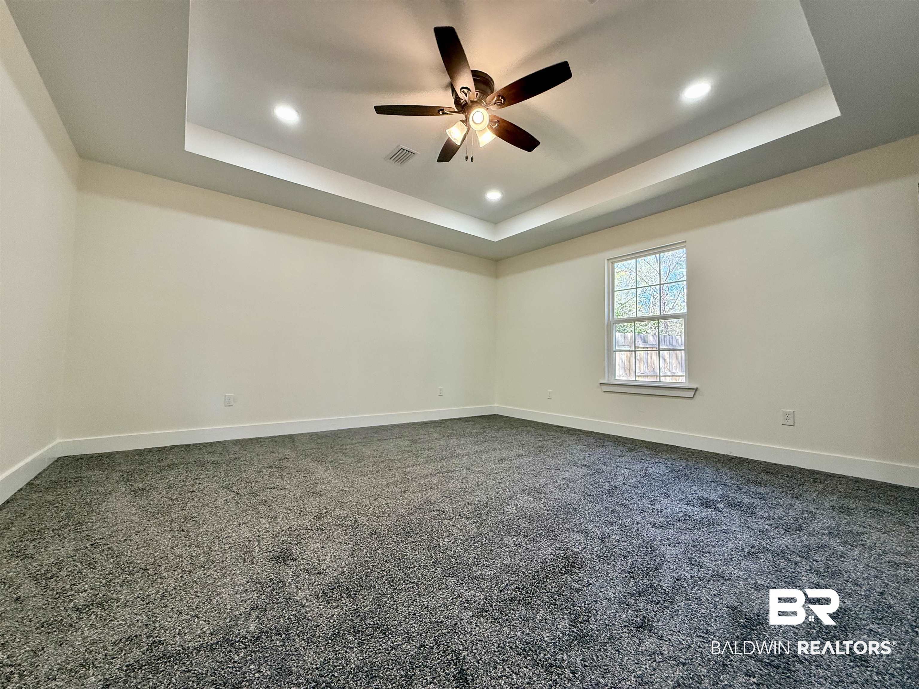 613 Forrest Avenue Brewton, AL 36426 - Photo 10 of 22 Unfurnished room featuring dark colored carpet, recessed lighting, a ceiling fan, and a tray ceiling