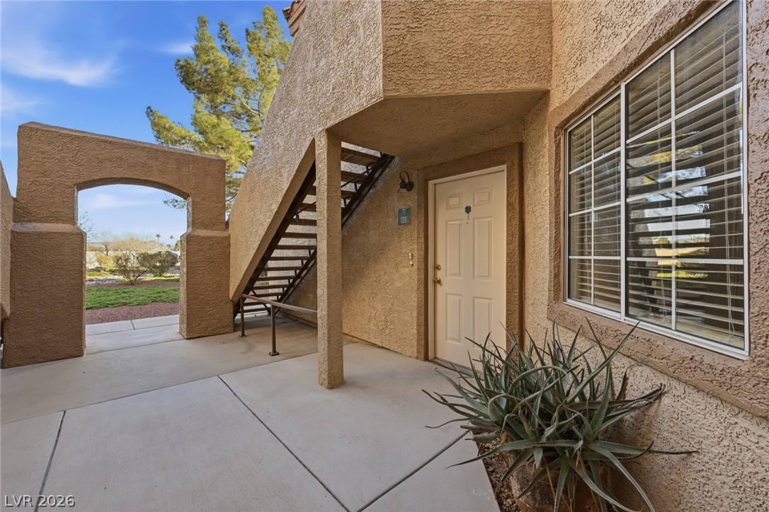 Doorway to property featuring stucco siding and a patio area