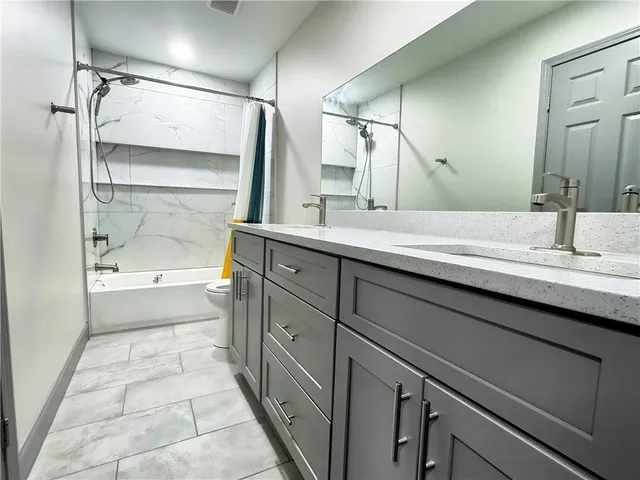 a bathroom with a double vanity sink mirror double and bathtub