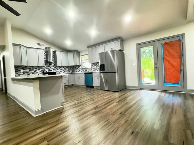 a kitchen with a refrigerator a sink and wooden cabinets