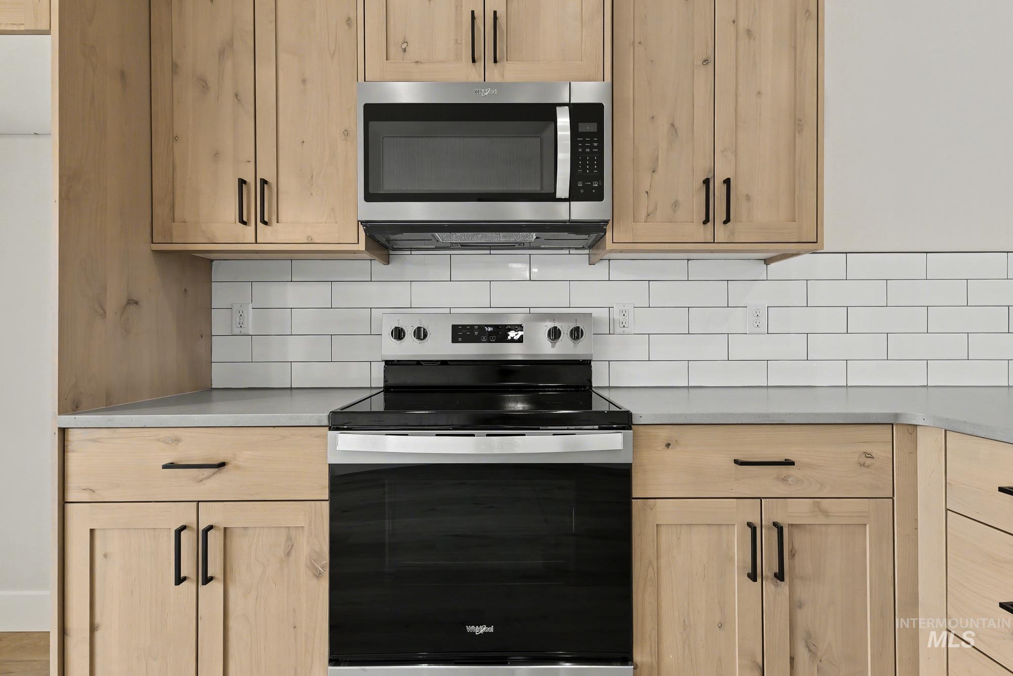 326 Packer Lane Homedale, ID 83628 - Photo 11 of 24 Kitchen featuring stainless steel appliances, light brown cabinetry, and tasteful backsplash