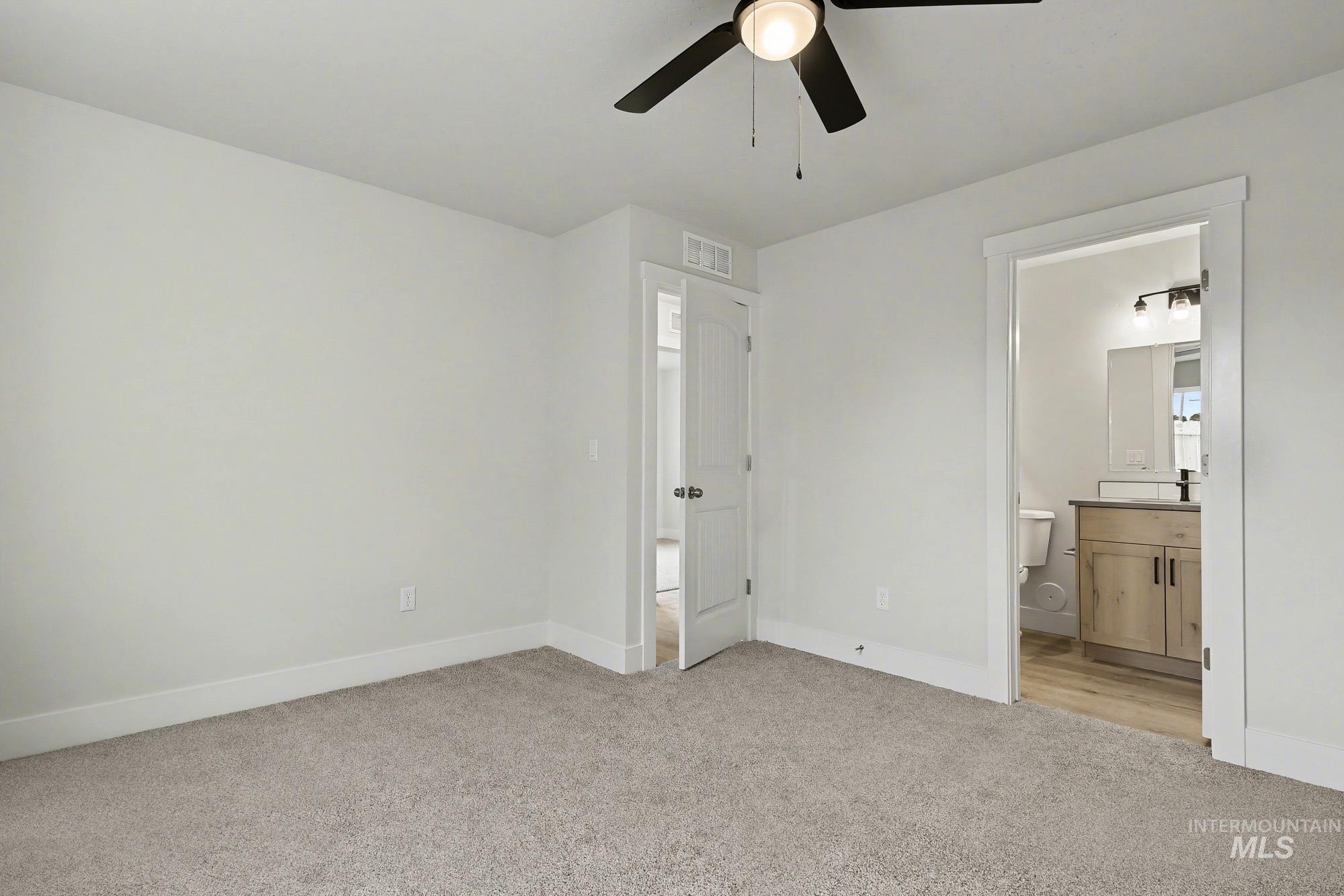 326 Packer Lane Homedale, ID 83628 - Photo 15 of 24 Unfurnished bedroom with light carpet, ensuite bathroom, and ceiling fan