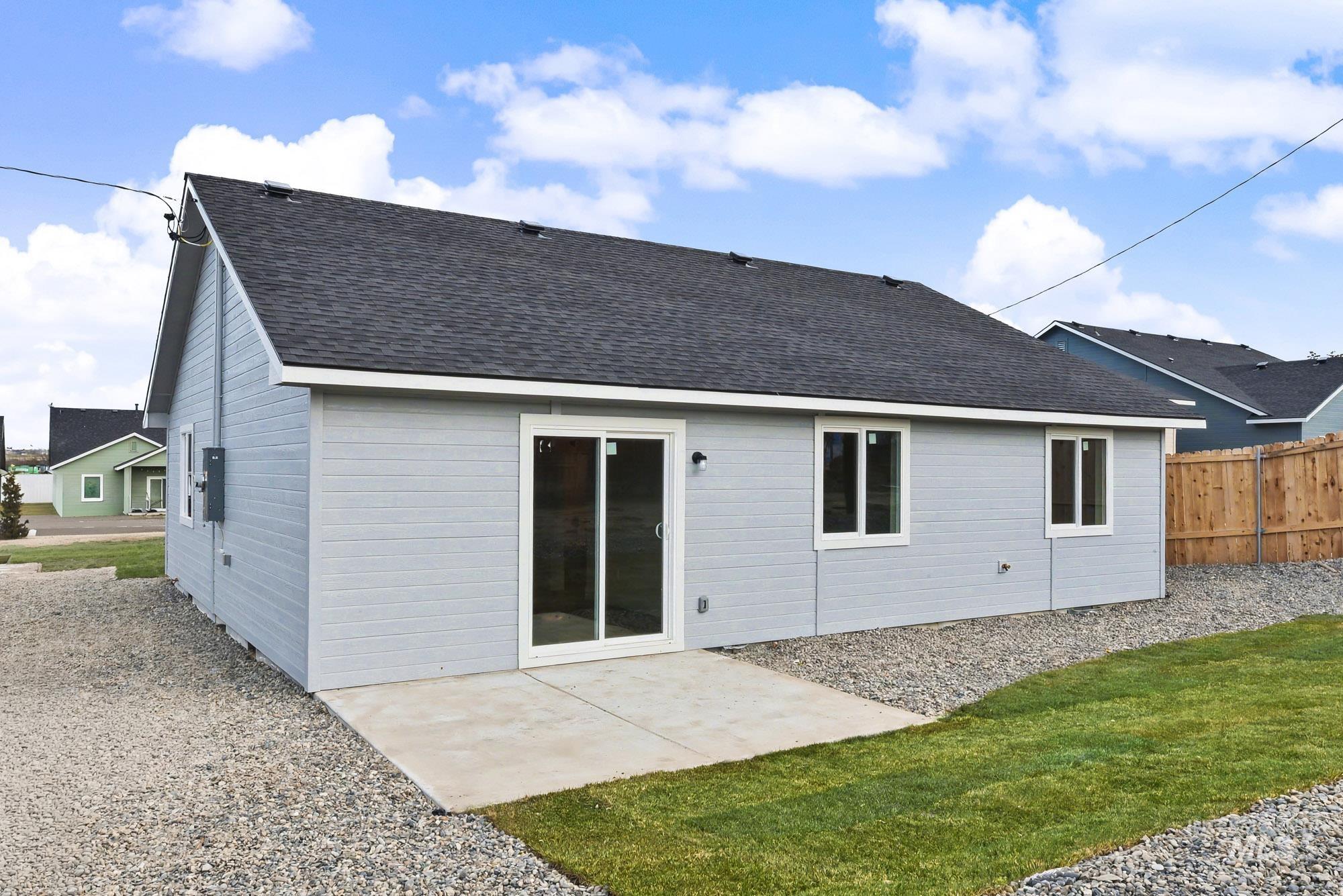 326 Packer Lane Homedale, ID 83628 - Photo 24 of 24 Back of house featuring a patio, a shingled roof, and a lawn