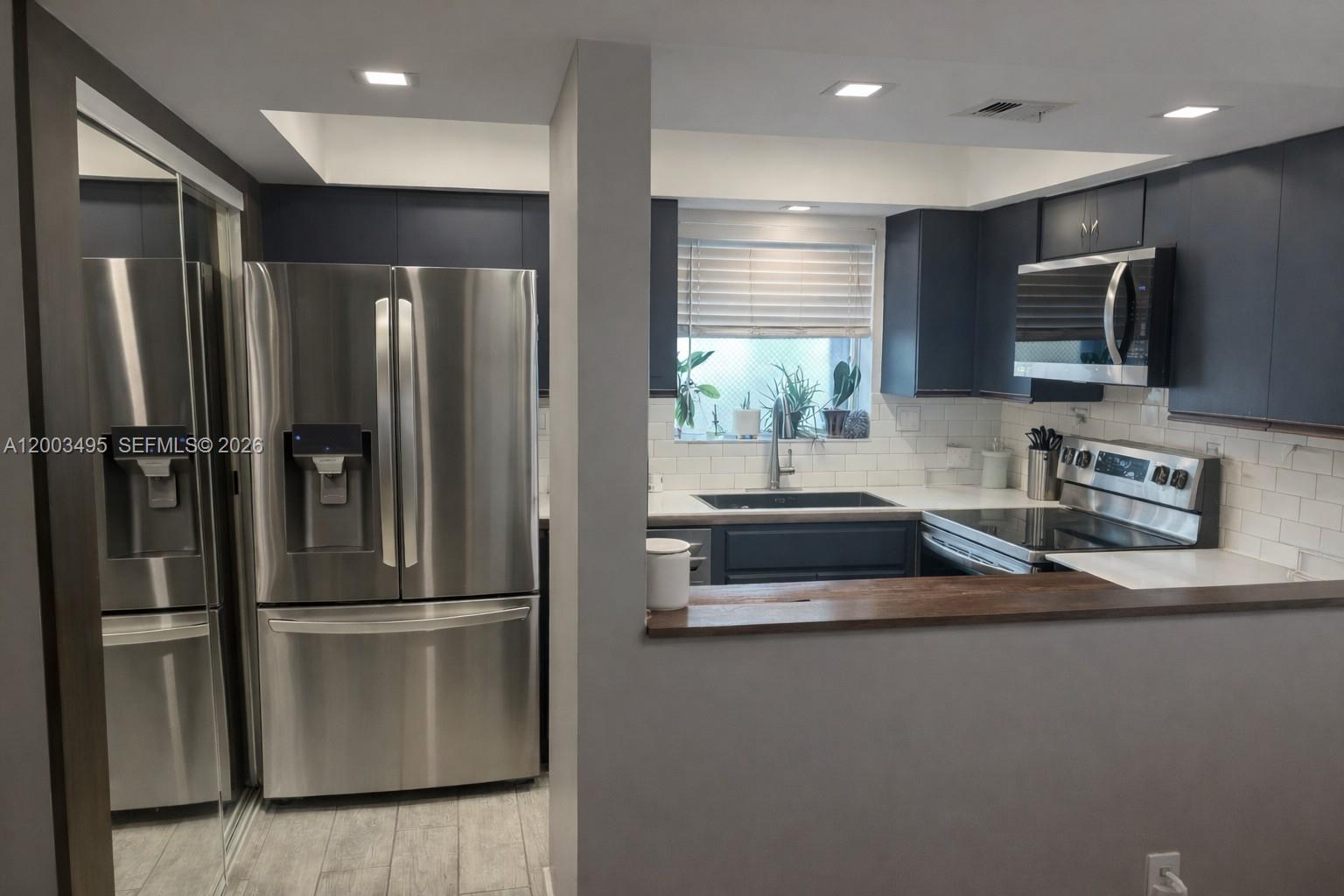201 Northwest 7th Street, Unit 103 Miami, FL 33136 - Photo 2 of 9 a kitchen with stainless steel appliances granite countertop a refrigerator and a sink