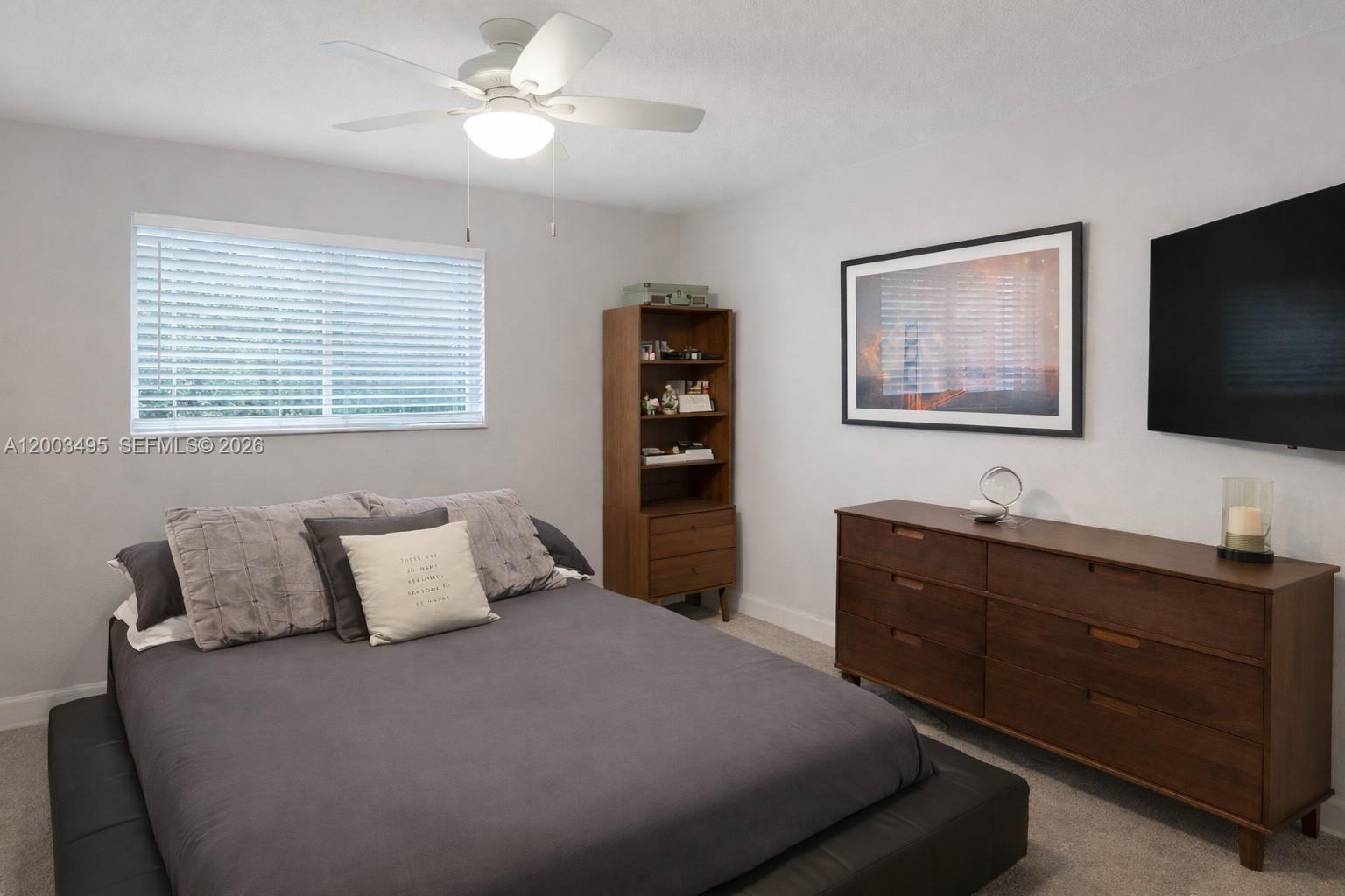 201 Northwest 7th Street, Unit 103 Miami, FL 33136 - Photo 4 of 9 a bedroom with a bed and a flat screen tv