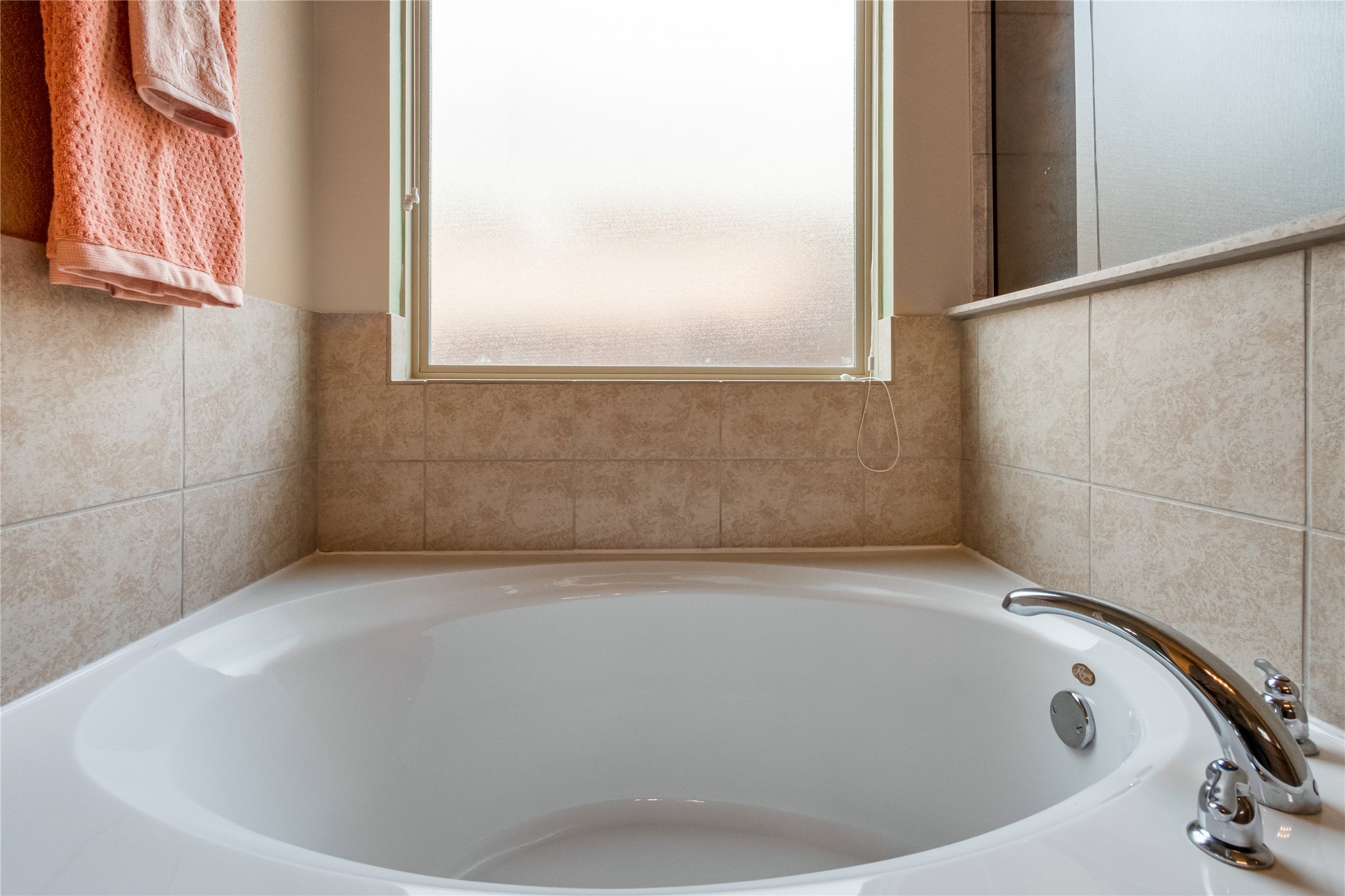 3413 Grail Hollows Road Pflugerville, TX 78660 - Photo 21 of 36 a white bath tub sitting in a bathroom next to a window