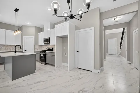 a kitchen with kitchen island a counter top space appliances and cabinets