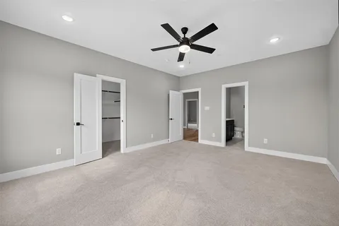 a view of a big room with a ceiling fan and windows