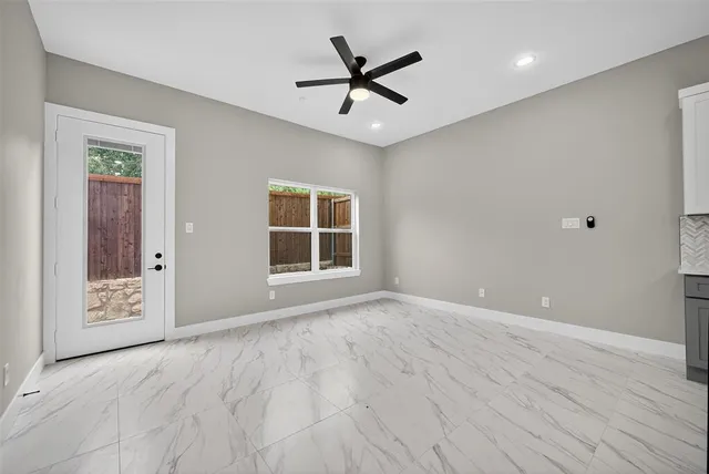 a view of a room with wooden floor and a ceiling fan