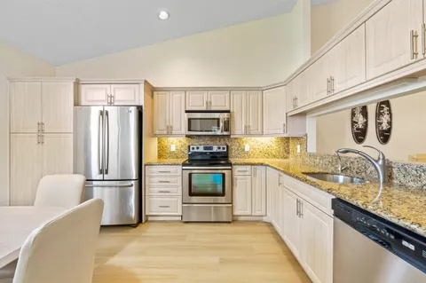 a kitchen with stainless steel appliances granite countertop a refrigerator stove microwave and sink