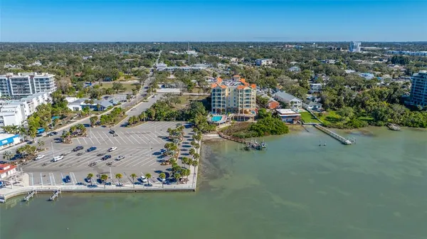 an aerial view of ocean and residential houses with outdoor space