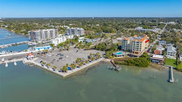 an aerial view of ocean and residential houses with outdoor space