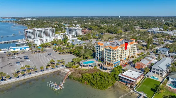 an aerial view of a city with lots of residential buildings ocean and mountain view in back