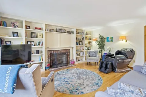 a living room with fireplace furniture and a rug