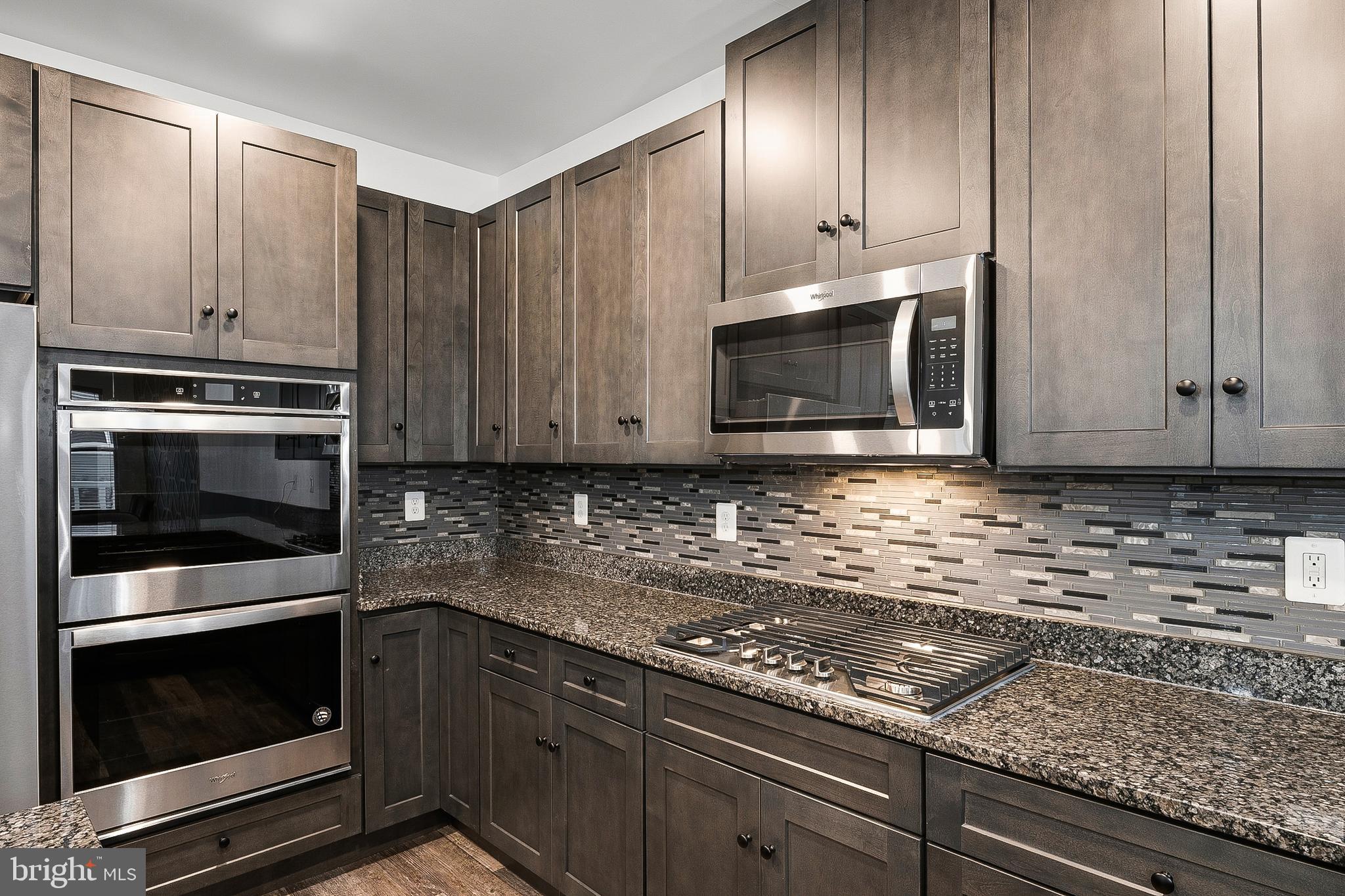 33 Greensborough Road Reisterstown, MD 21136 - Photo 18 of 40 a kitchen with granite countertop cabinets stainless steel appliances and wooden floor